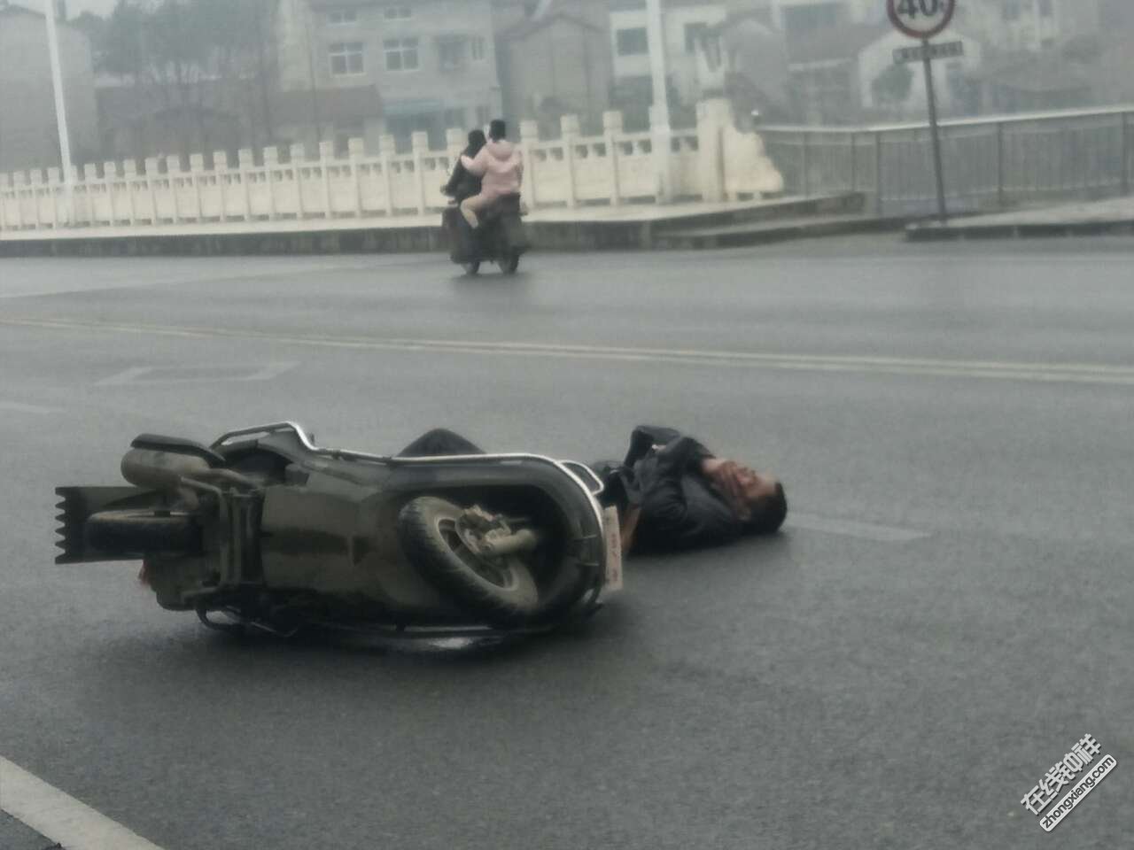 一摩托车摔倒,估计摔的不轻,路人已经拨打电话